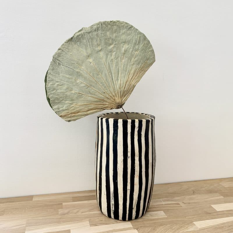 Vase Sejnane en terre cuite artisanale rayé noir et blanc avec feuille de lotus séchée